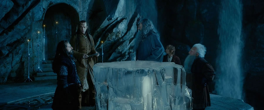 Elrond, despite Dwarvish recalcitrance, reads the secret runes of Thror’s map atop a transparent crystalline table (Féanorean Plexiglas®?)
