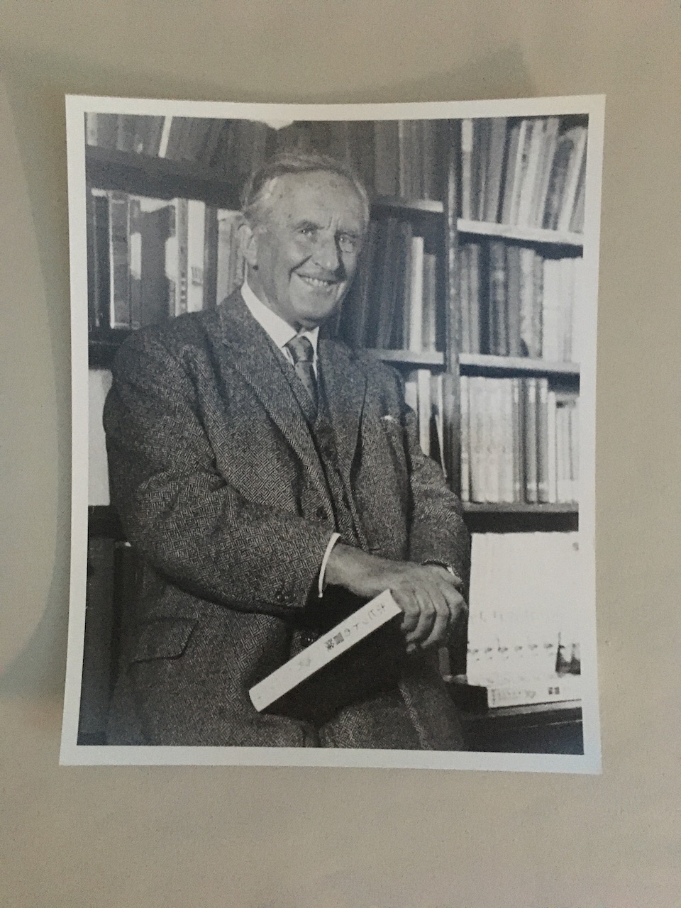 Exclusive Photographic Print: J.R.R. Tolkien stands before his bookshelves, laughing, with a Japanese edition of his work in hand